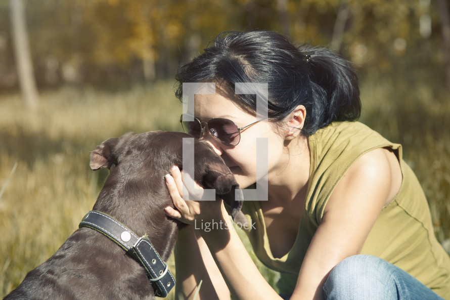 a woman kissing her dog 
