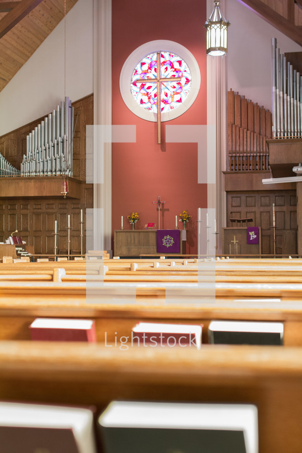 hymnals in church pews and organ pipes 
