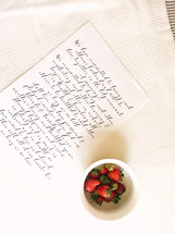 a note and strawberries in a bowl 