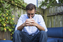 a man praying in his backyard 