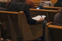 Writing sermon notes in church