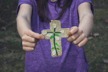 child holding a handmade cross