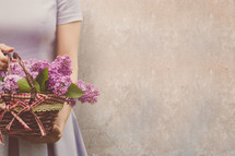 a woman holding a basket of flowers 