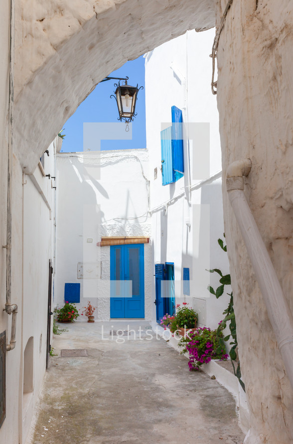 Typical view of Ostuni with houses with white walls and blue window frames. Stone buildings with southern Italy style