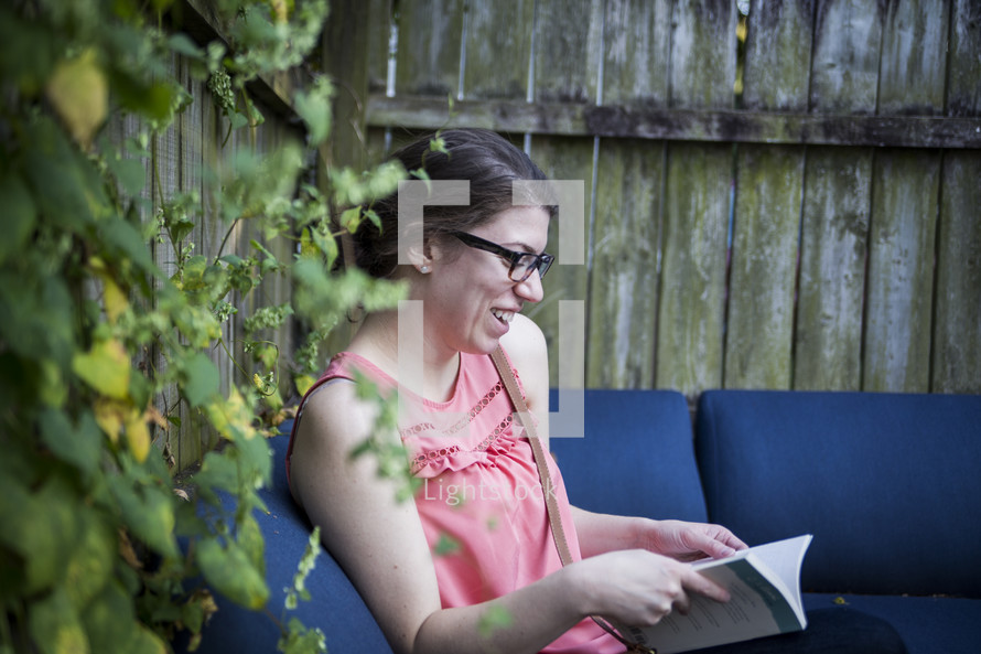 a woman reading a Bible in her backyard 
