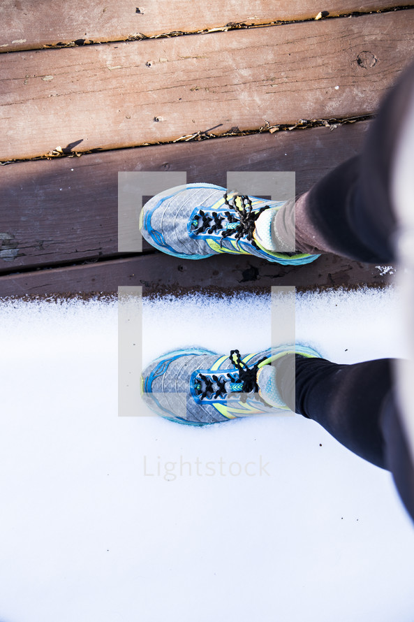 sneakers standing on a deck with snow 