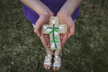 girl holding a handmade Easter cross craft