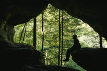 a man sitting in a cave 