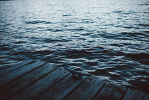 wood dock and choppy lake water 