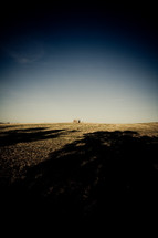 a distant barn and shadows over a field on a farm