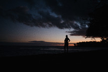 silhouette of a man standing on a beach 