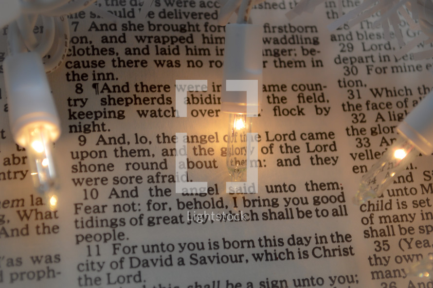 Christmas lights on the pages of a Bible 