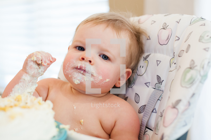 baby in a high chair with a messy face 