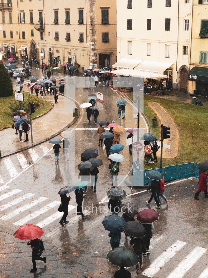 crowds of people walking in the street with umbrellas in the rain 