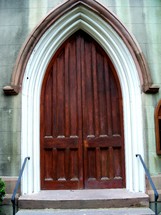arched wooden doorway entrance to an old historic church in a historic area of downtown. 