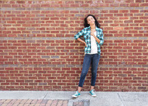 girl standing in front of a brick wall 