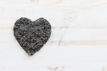 heart shaped ashes on white wood background 
