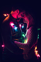 couple wrapped in Christmas lights 