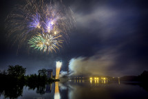 fireworks bursting in the night sky over water 