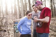 friends looking at a map on a cellphone before a hike 