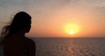 Girl Looking Into The Sunset over the ocean