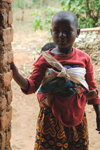 young girl with a papoose and baby in Rwanda 