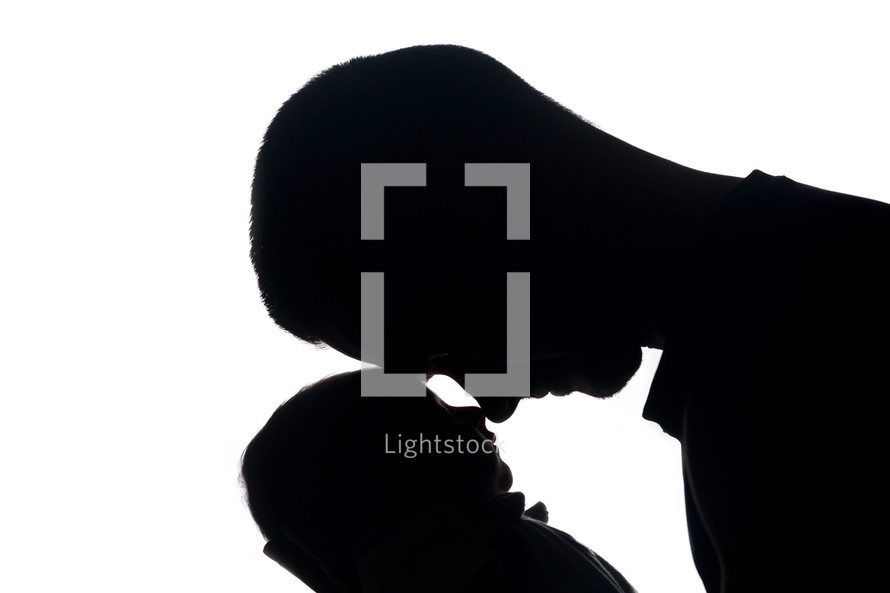 silhouette of a father cradling a newborn 