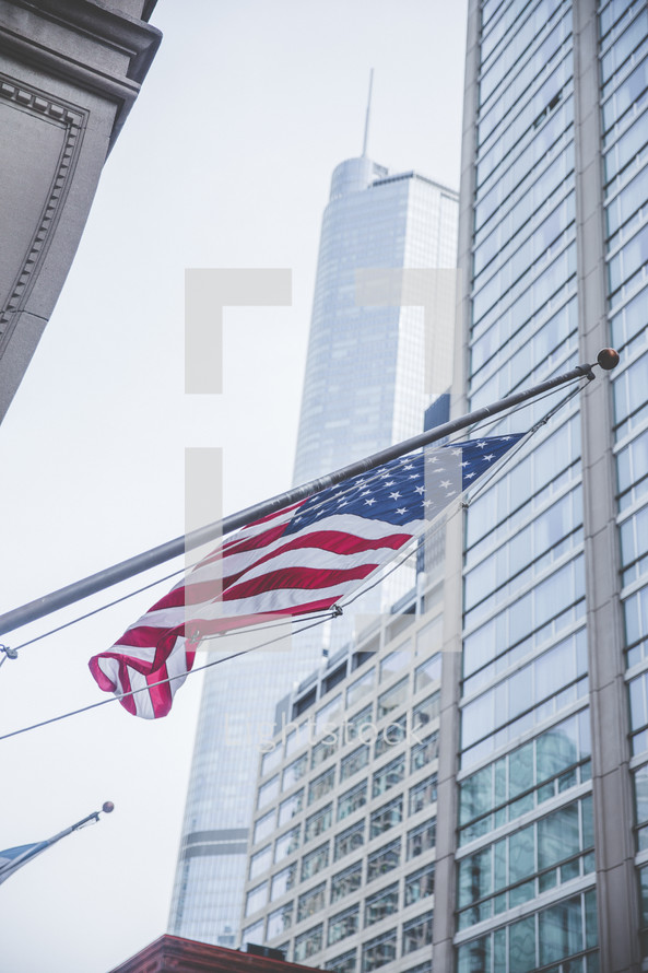 American flag on a flagpole in a city 