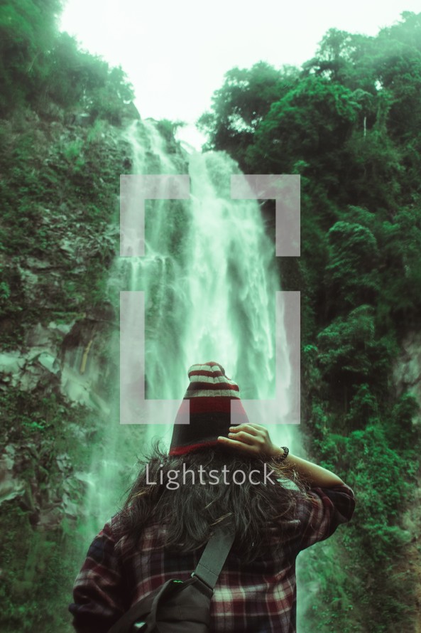 a person standing in front of a waterfall 