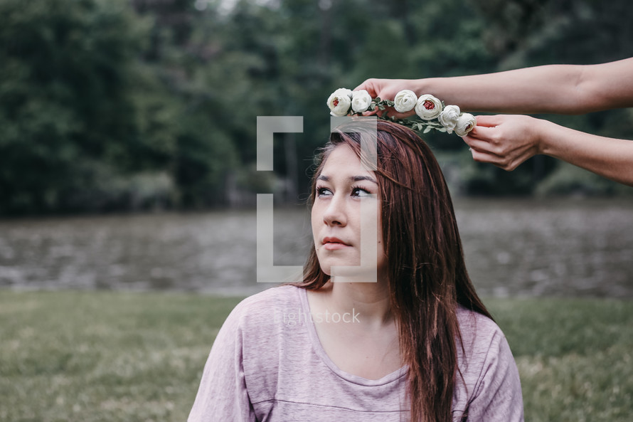 placing a crown of flowers on a woman's head 