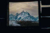 window view of rugged snow covered mountains 