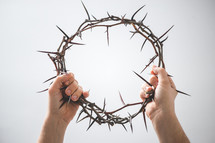 Jesus holding up a crown of thorns 
