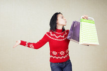 a woman in a red sweater with shopping bags 