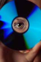 Woman peeping through compact disk