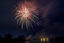 fireworks bursting in the night sky over water 