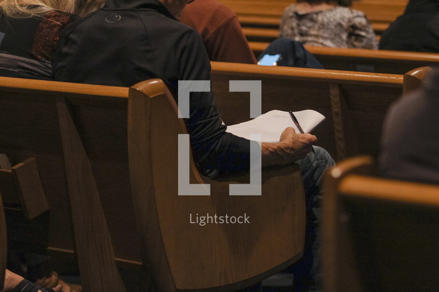 Writing sermon notes in church