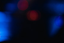blue and red bokeh lights against a black background 