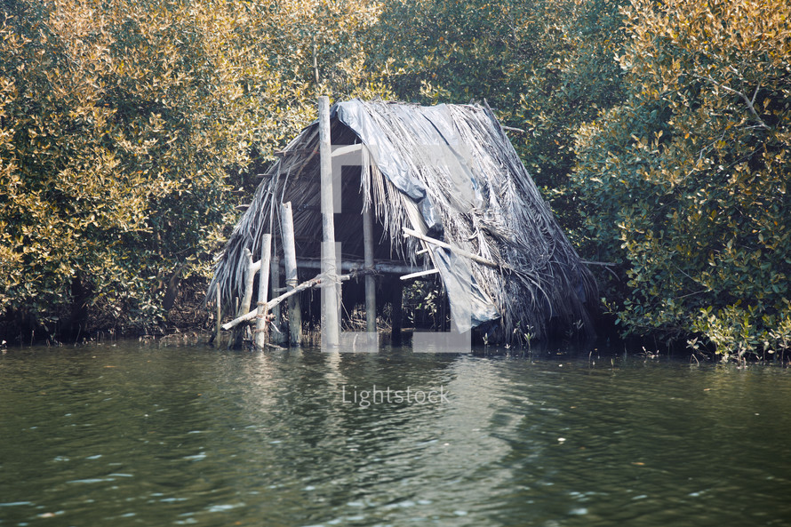 straw hut over a river 