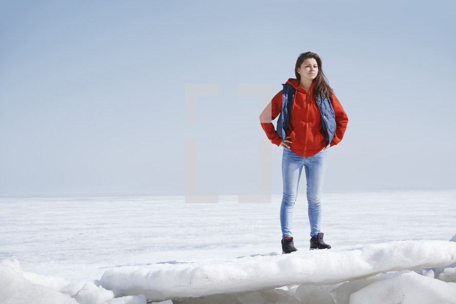 a young woman standing in a snow covered landscape 
