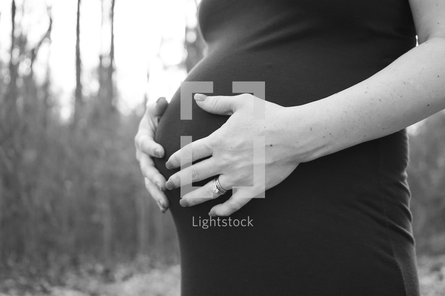 a pregnant woman with her hands on her belly