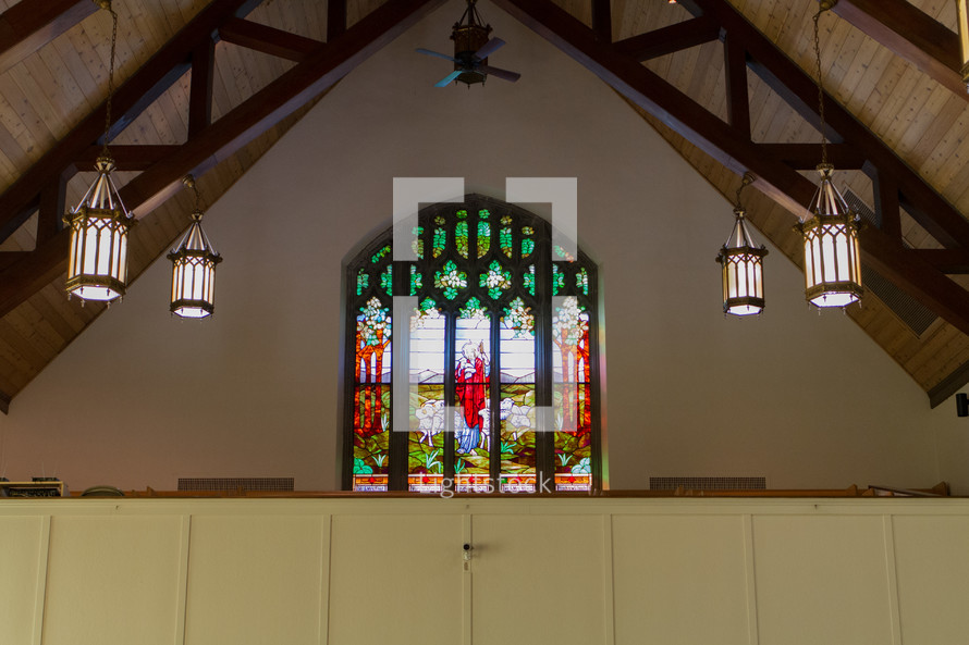 stained glass window and hanging lights in a church 
