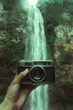 a camera in front of a waterfall 