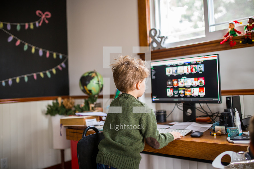 a child in front of a computer looking for Christmas music 