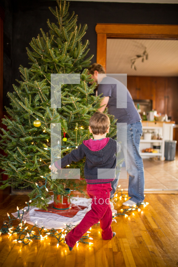 father and son decorating a Christmas tree 