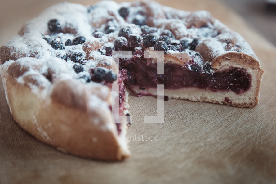 Cranberry cake with blackberry on a wooden table