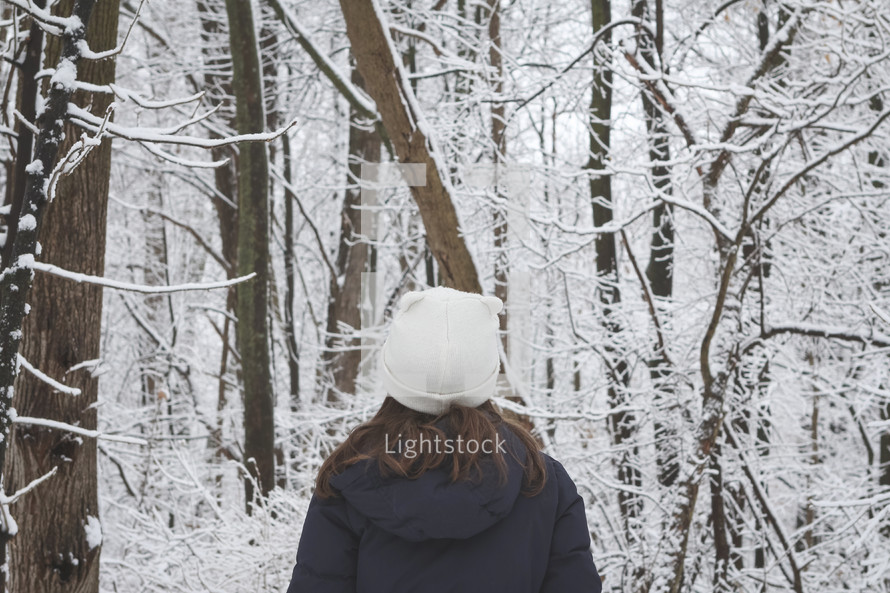 girl standing outdoors in a forest in winter 