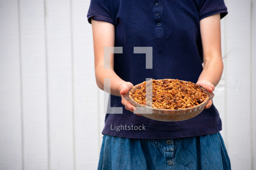 girl holding a casserole dish 