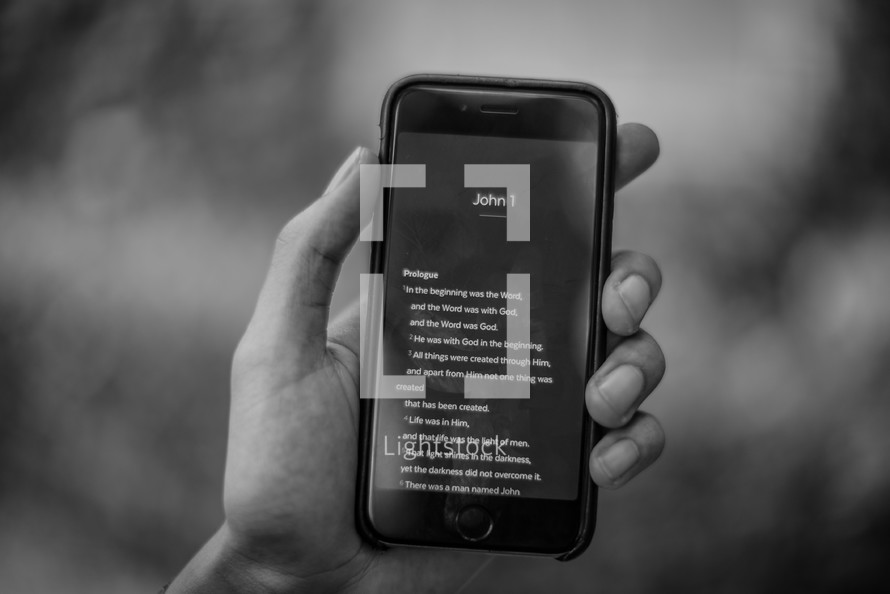 a man reading scripture from a cellphone screen 