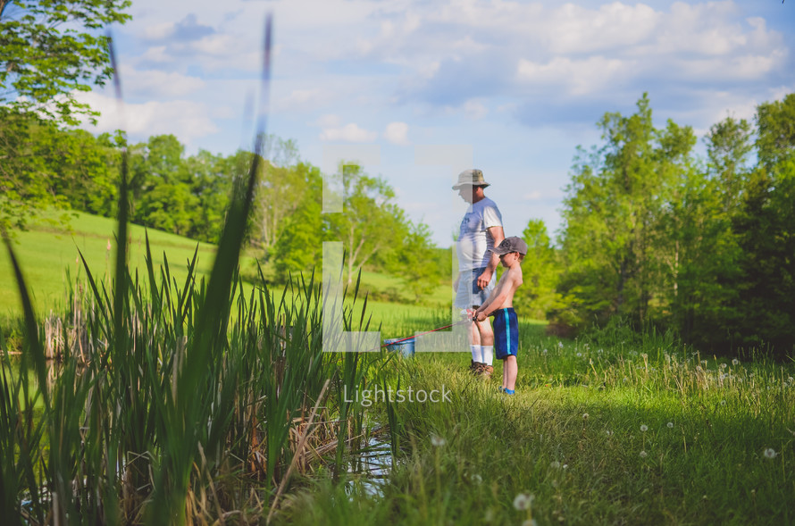father and son fishing in a pond 