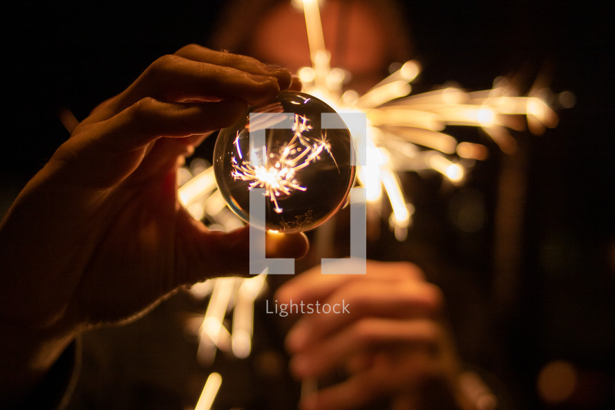 sparks from a sparkler and glass orb 